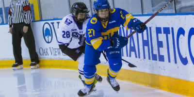 Dayle Chinnick skating toward the puck in a game against the Western Mustangs