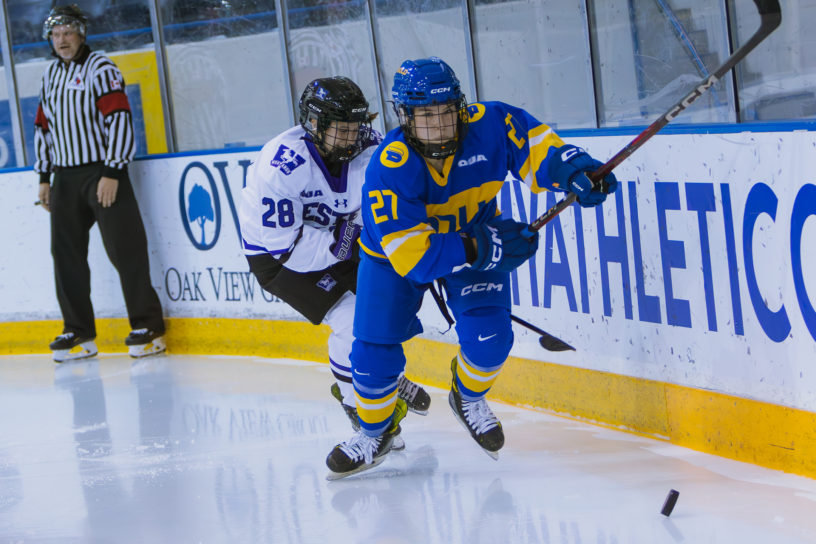 Dayle Chinnick skating toward the puck in a game against the Western Mustangs