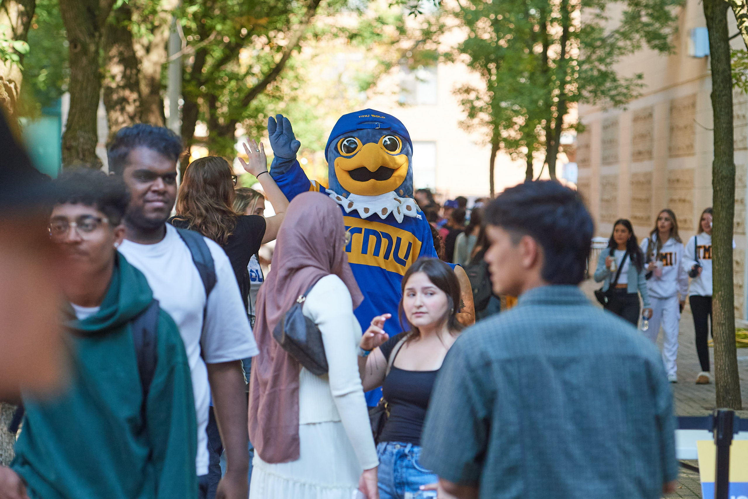 Frankie the falcon amongst students in a crowd