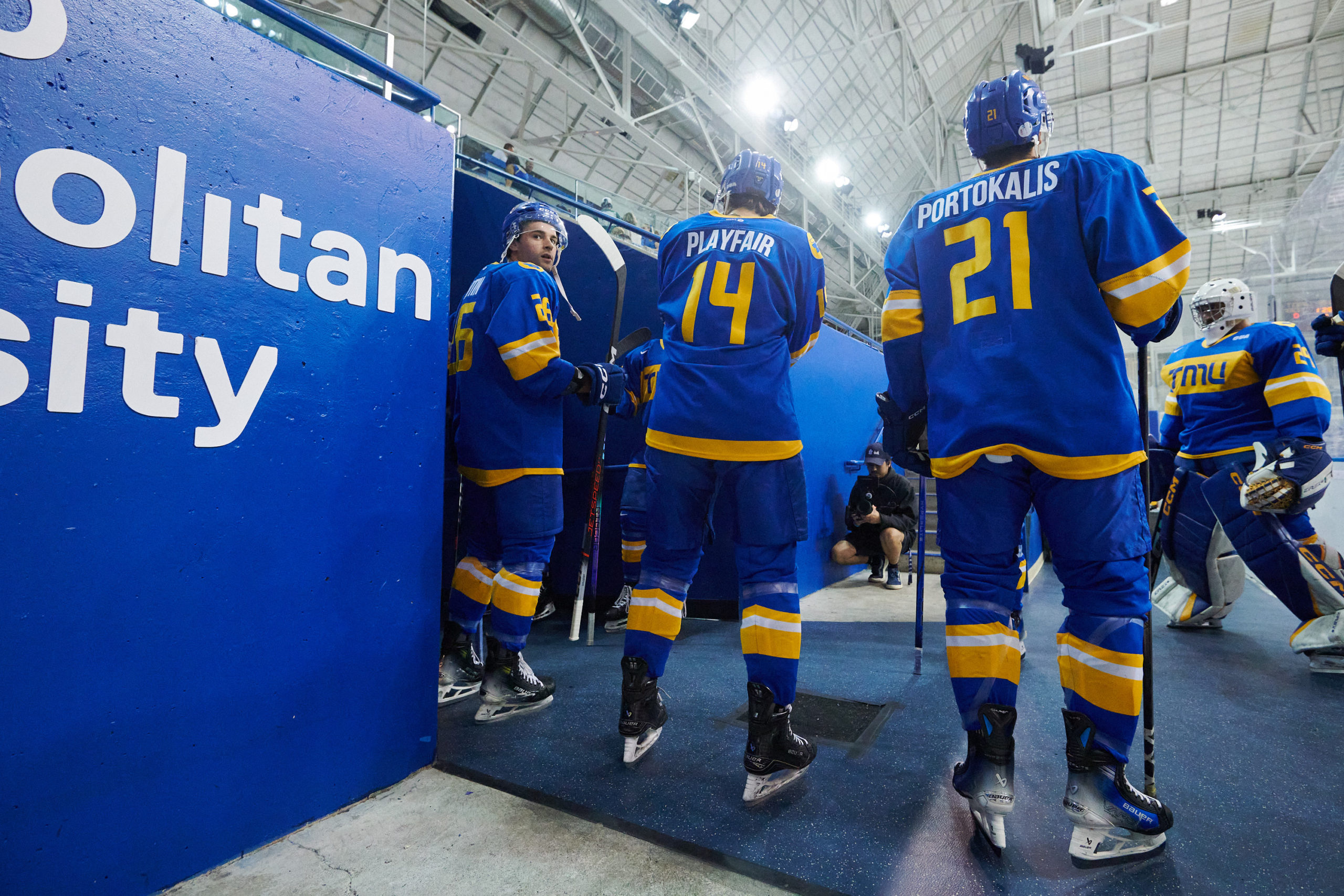 Bold men's hockey players Will Portokalis, Chris Playfair and Ian Martin line up between the tunnel to the changeroom and the bench before a game