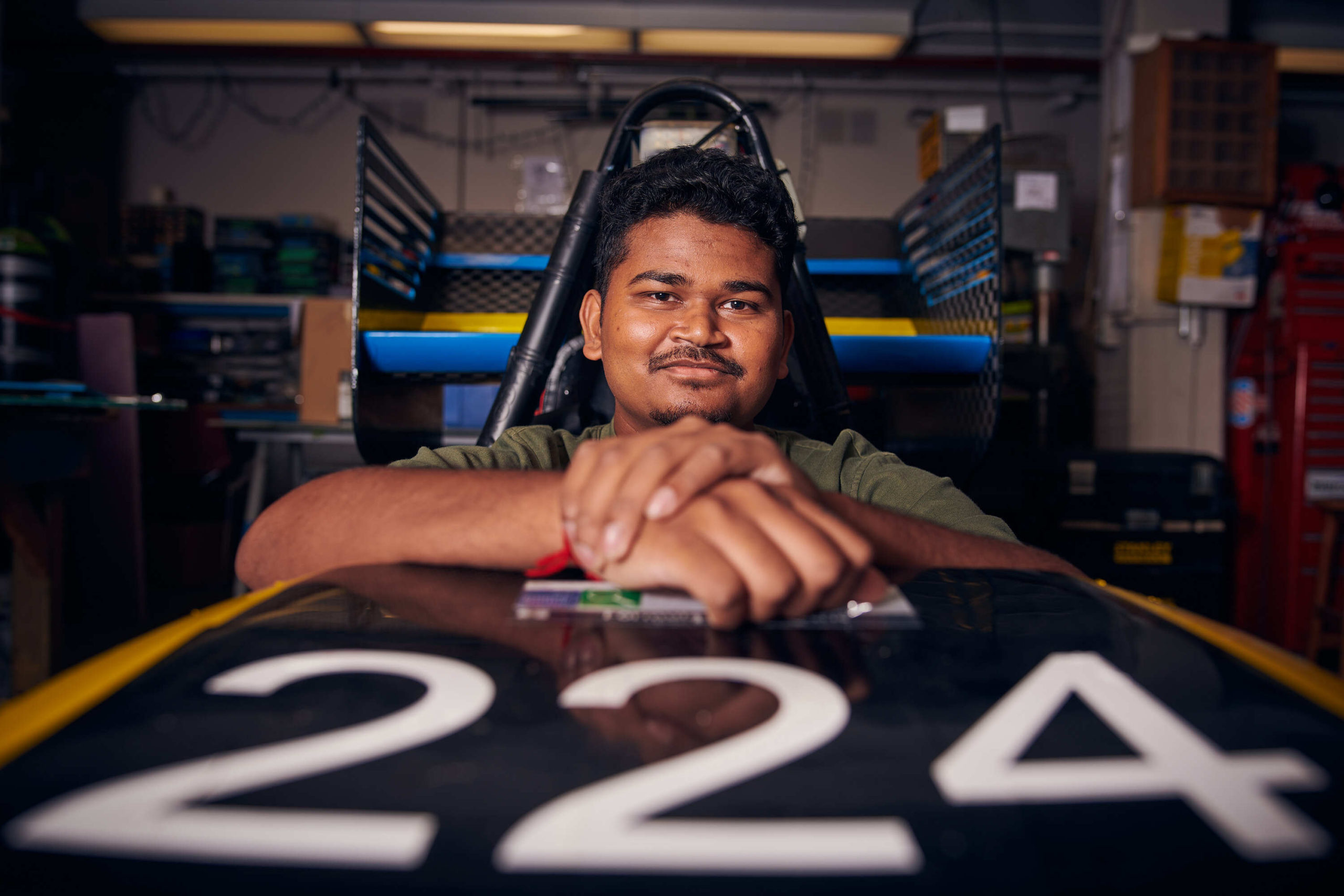 A close up photo shows Rhythm Patel sitting in the TM-4 race car with the numbers 224 on the front.