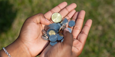 A close-up shot of a person's hand holding coins.