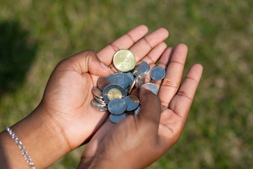 A close-up shot of a person's hand holding coins.