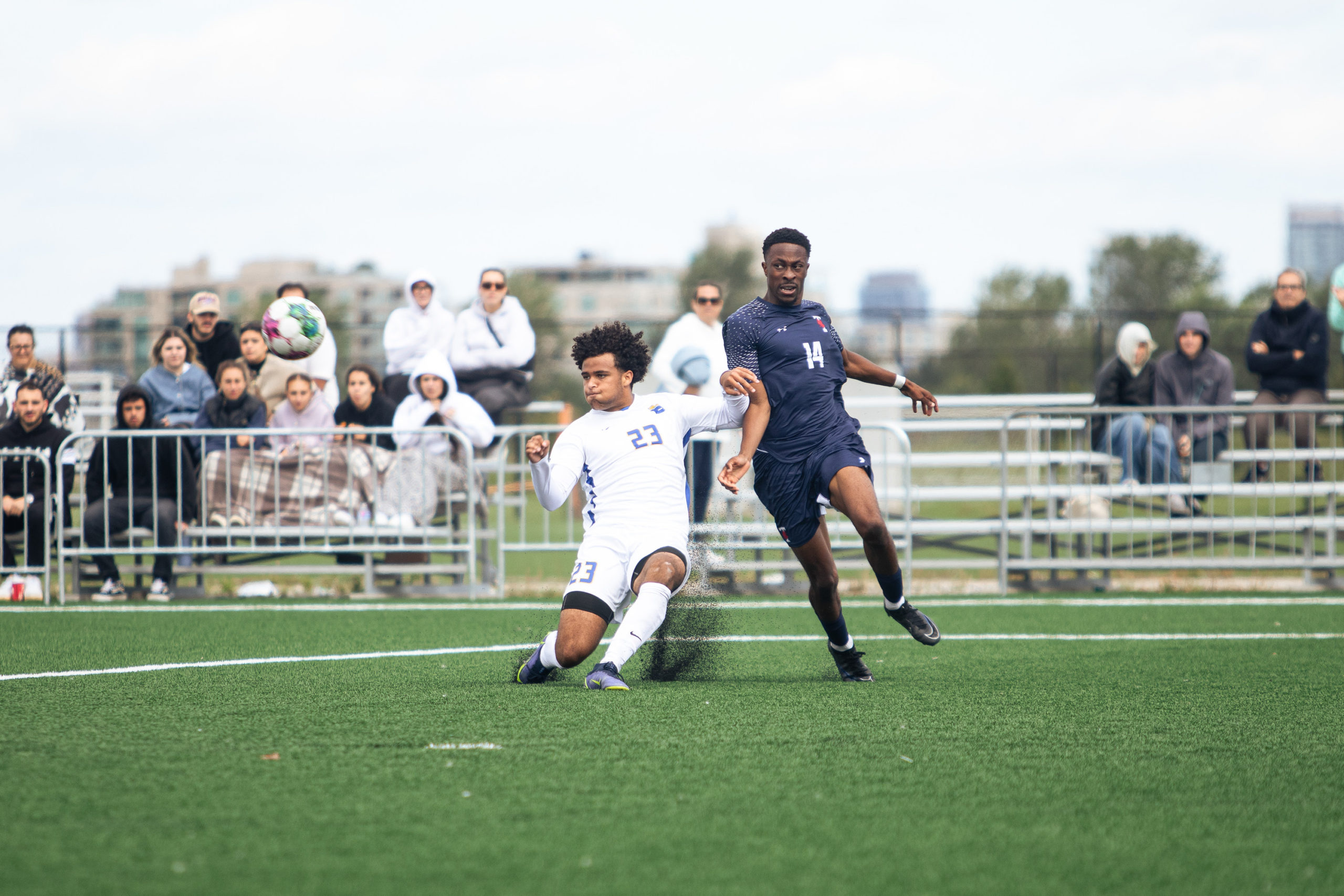 Noah Pickering clearing the ball in a challenge against an U of T player