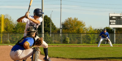 A U of T Varsity Blues baseball player bats against the TMU Bold