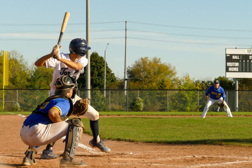 A U of T Varsity Blues baseball player bats against the TMU Bold