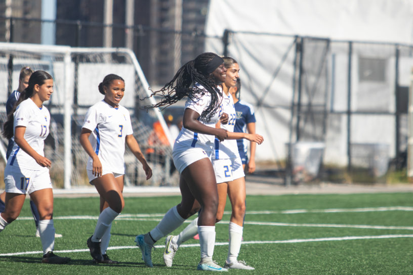 Members of the TMU Bold women's soccer team congratulate Aalayah Lully after she scored a goal