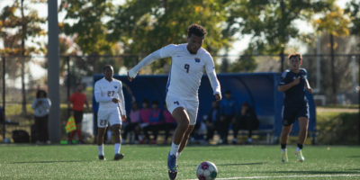 Jevontae Layne dribbles a soccer ball into the box