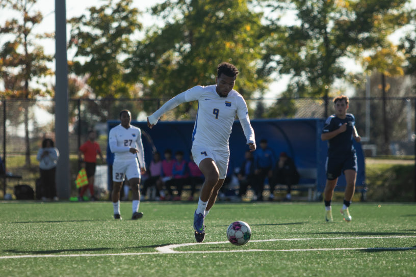 Jevontae Layne dribbles a soccer ball into the box