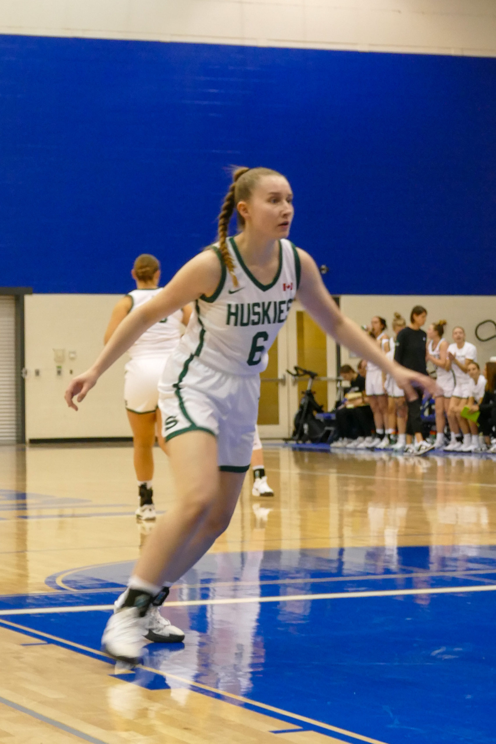 A Saskatchewan Huskies player runs up the court in a basketball game