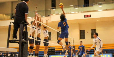 Kai Higuchi touching the ball, while U of T's first line is jumping to block the shot