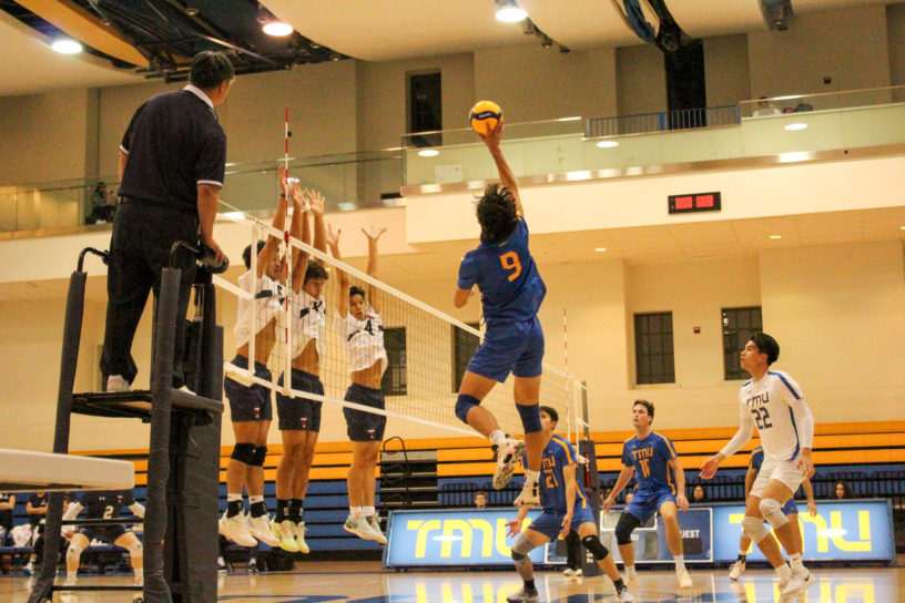 Kai Higuchi touching the ball, while U of T's first line is jumping to block the shot