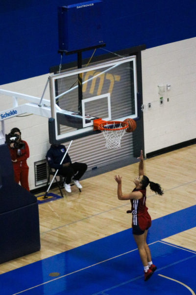 An Acadia Axewomen player does a layup on a net