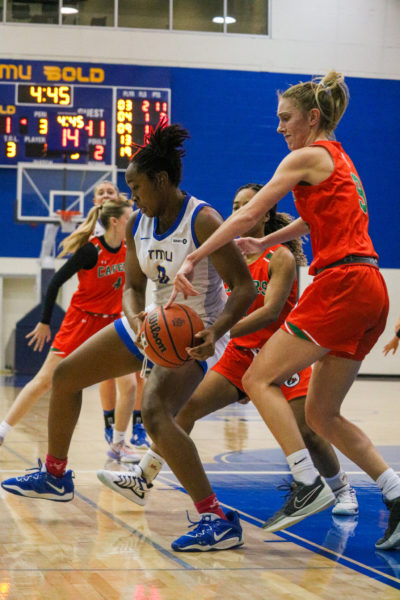 Zoe Idahosa holds a basketball away from Cape Breton Capers defenders