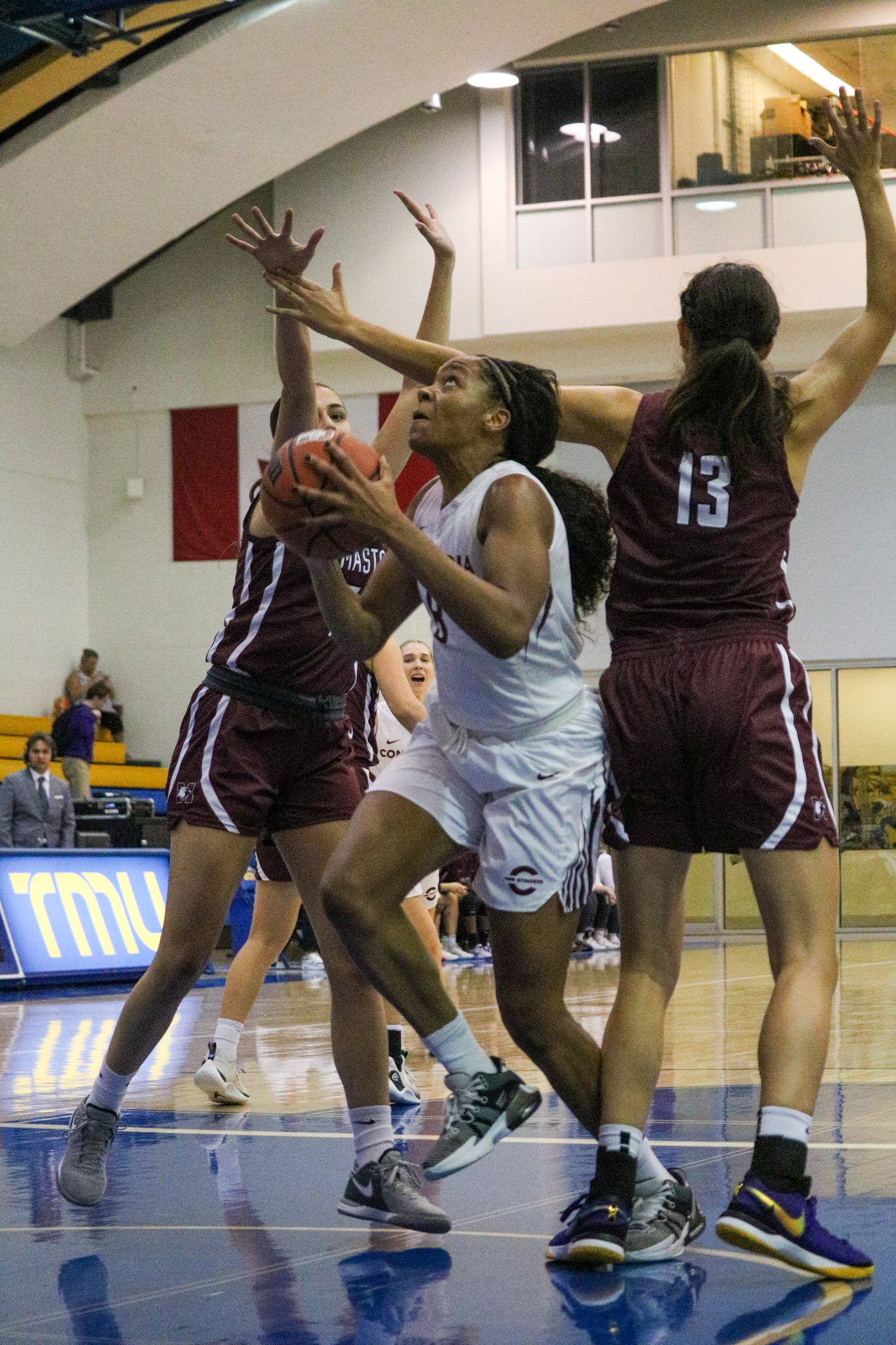 A Concordia Stingers player goes to the basket for a layup against McMaster Marauders players