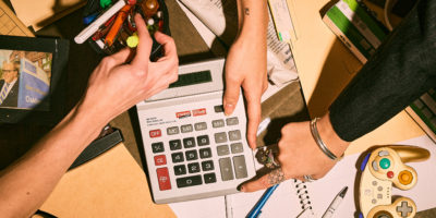 A overhead shot of hands grabbing at random office items in a break room