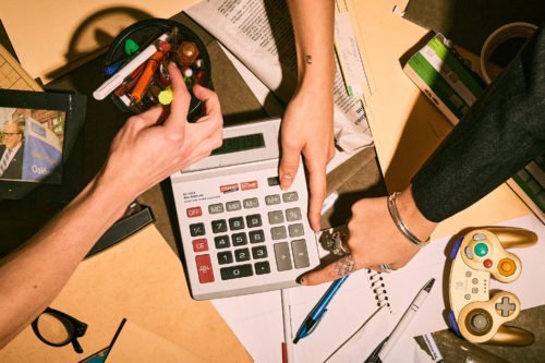 A overhead shot of hands grabbing at random office items in a break room