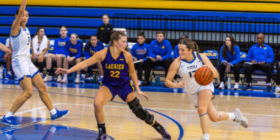 Catrina Garvey dribbling with the ball against the Laurier Golden Hawks