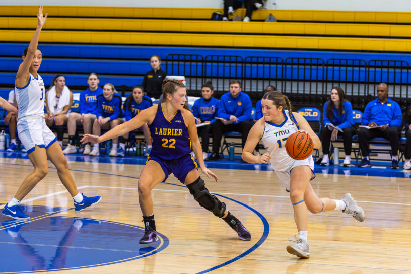 Catrina Garvey dribbling with the ball against the Laurier Golden Hawks