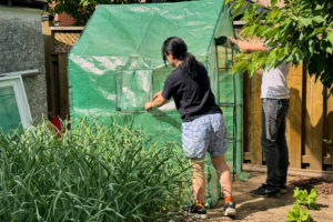 A gardener fixes a sheltered area of a large garden.