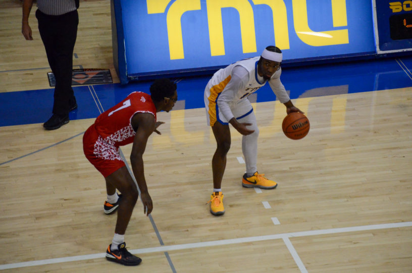 Javier Gilgeous-Glasgow dribbles the ball as he approaches an Algoma defender near the scorer's table