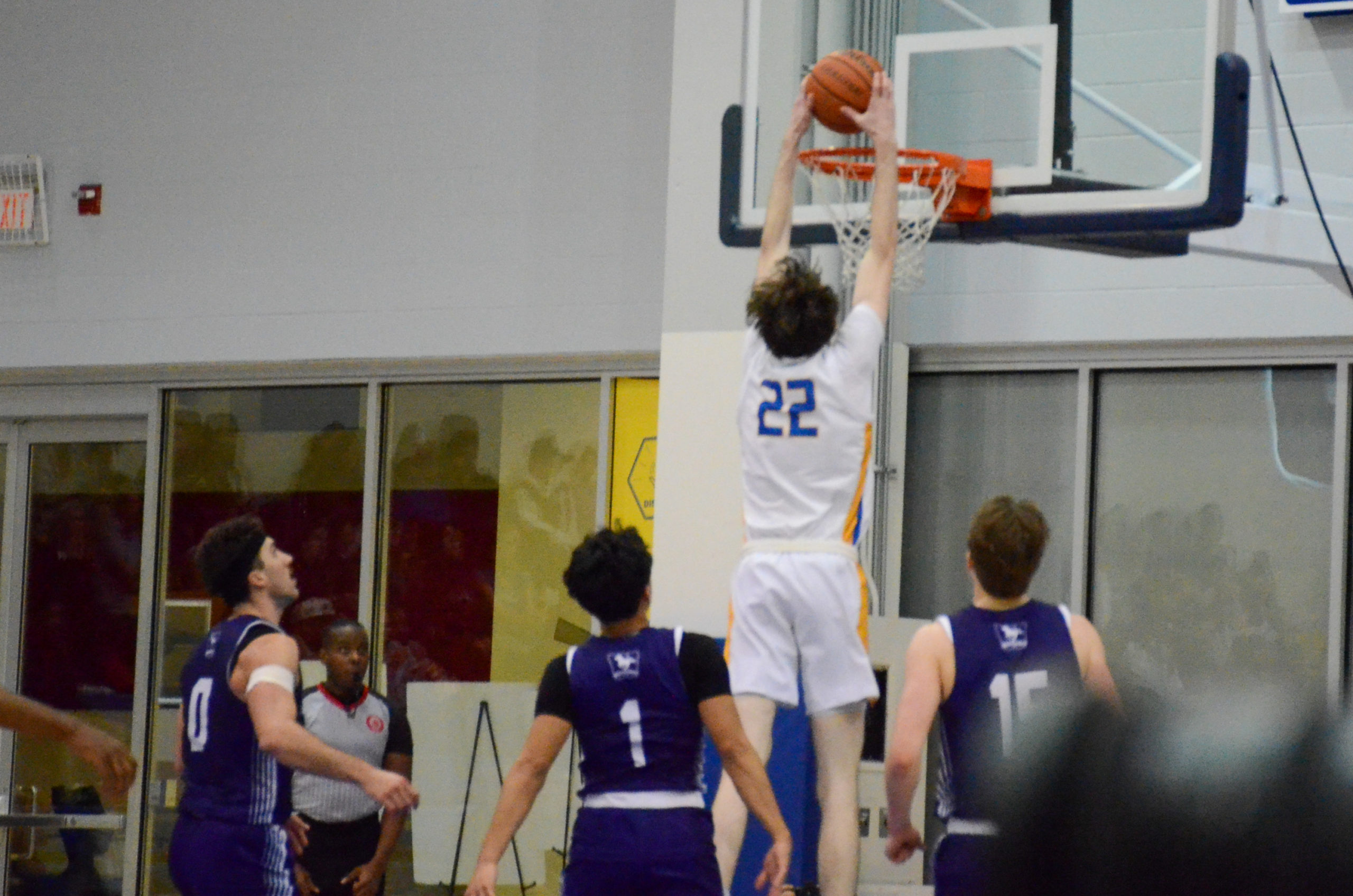 Aidan WIlson dunks a basketball against the Western Mustangs