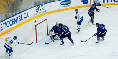 Kevin Gursoy shoots a puck into the net from the side of the net