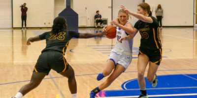 Kaillie Hall battles through two defenders grabbing at the basketball