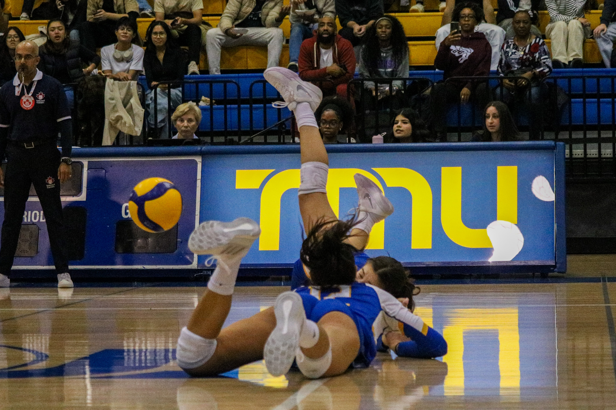 A couple of TMU Bold players colliding in the floor 