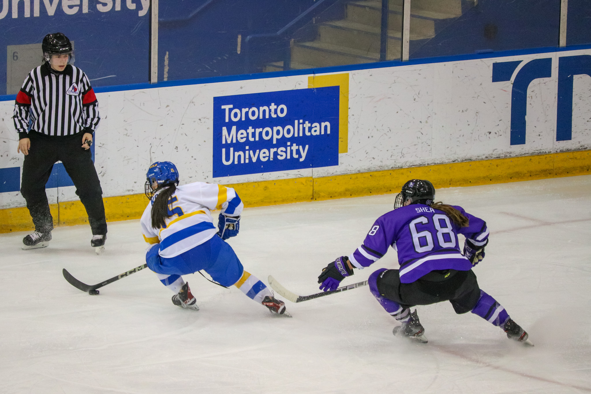 Kayla Kondo dragging the puck away from a Western player