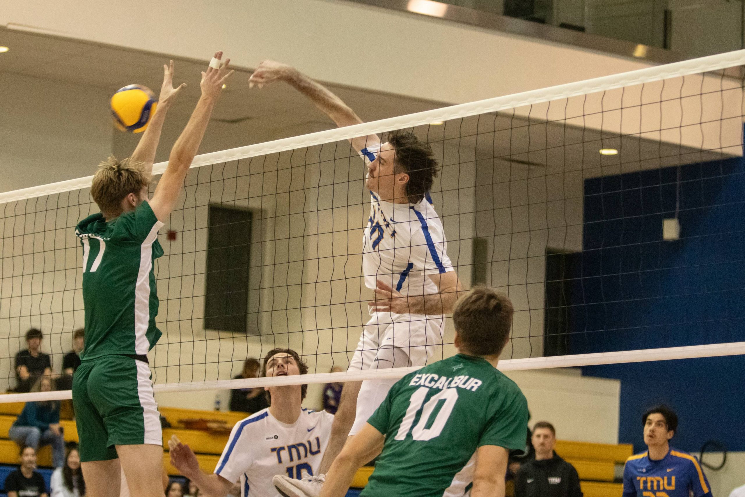 Alex King hitting the ball over the net