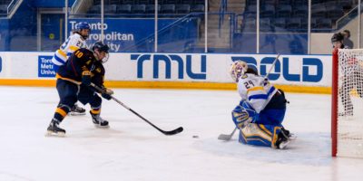 Alexia Stratos crouching about to catch the puck