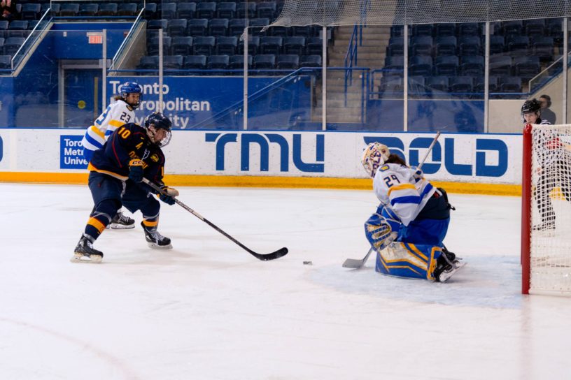 Alexia Stratos crouching about to catch the puck