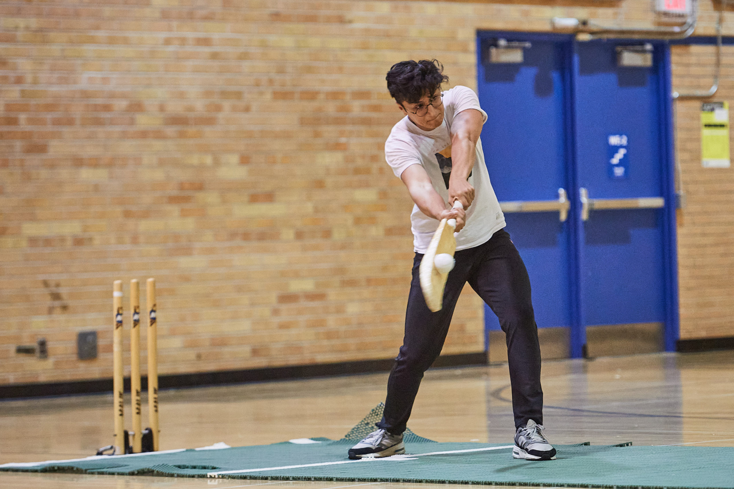 a player hitting the ball with a cricket bat