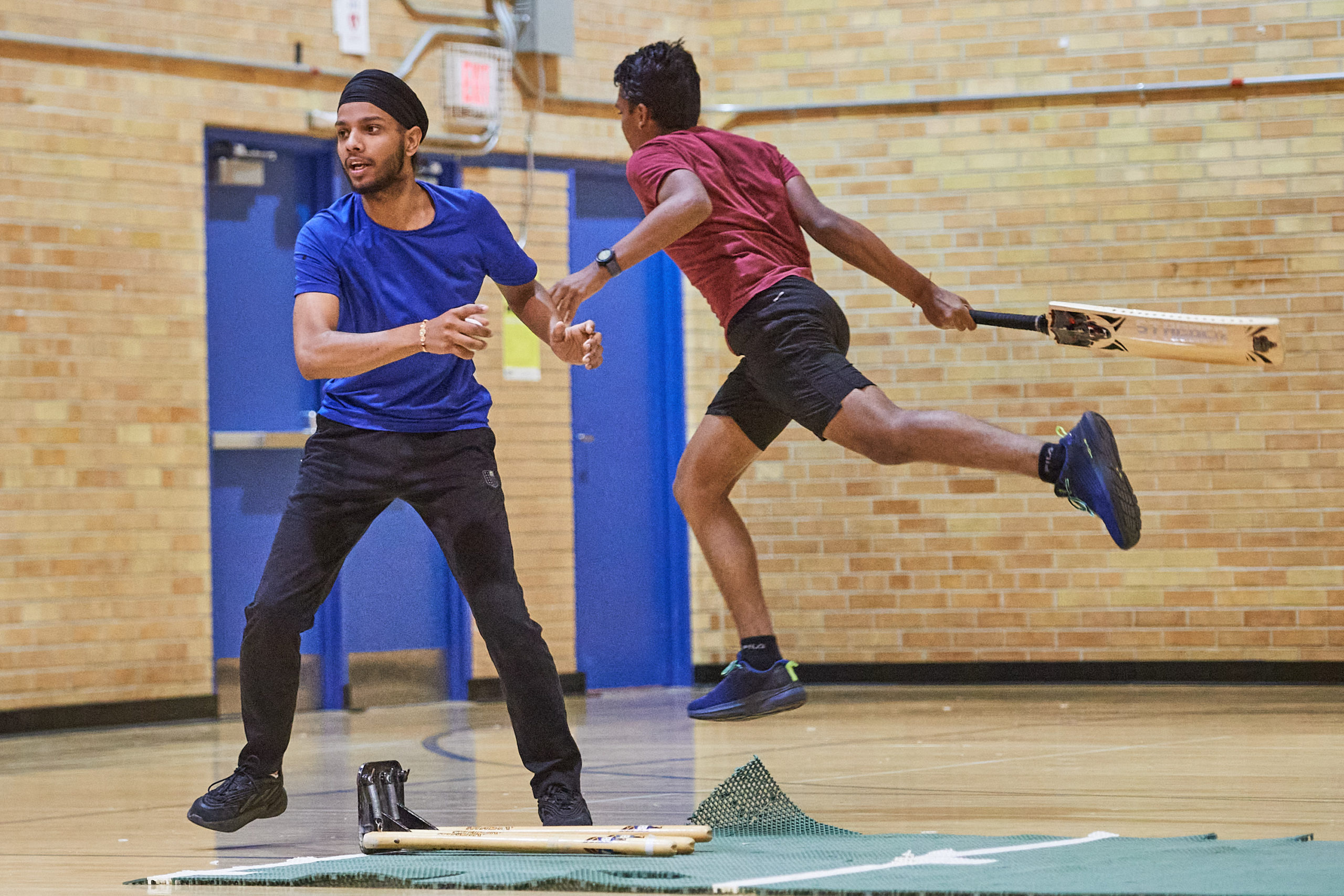 a player jumping to complete a run in cricket