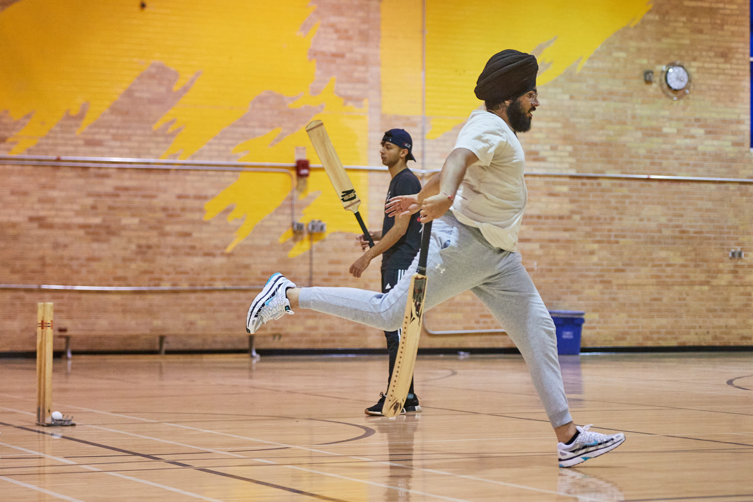 a player jumping to complete a run in cricket