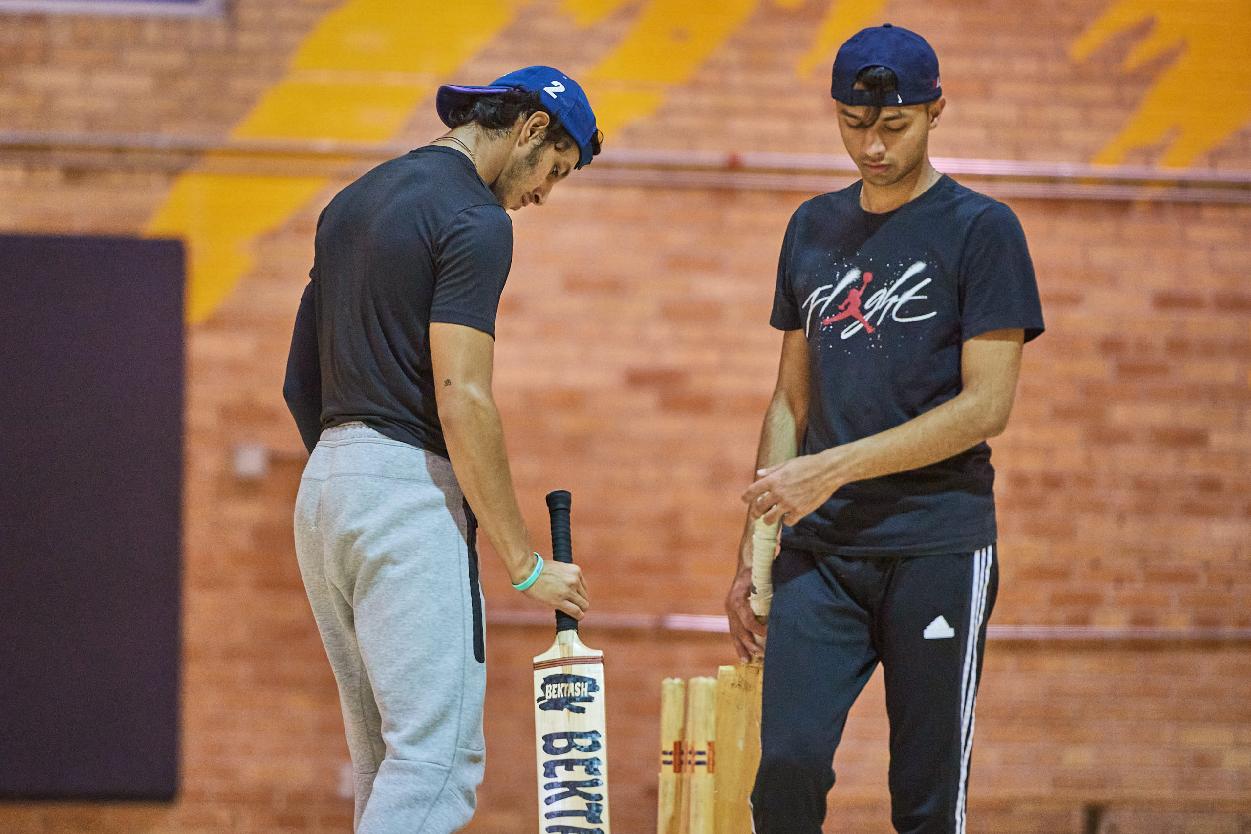 two players looking at their cricket equipment