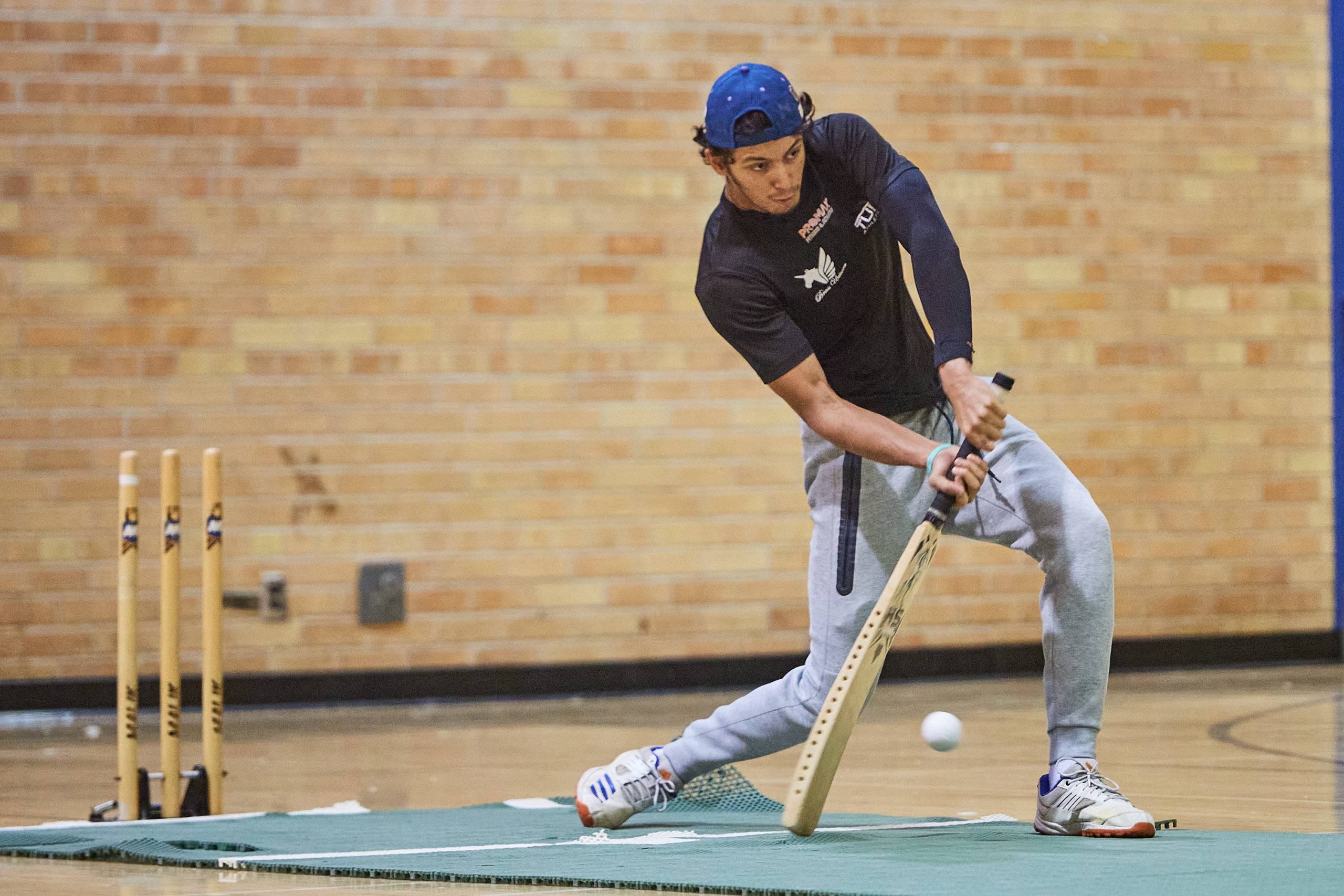 Hrishik Mehta batting the ball in the kerr hall gym