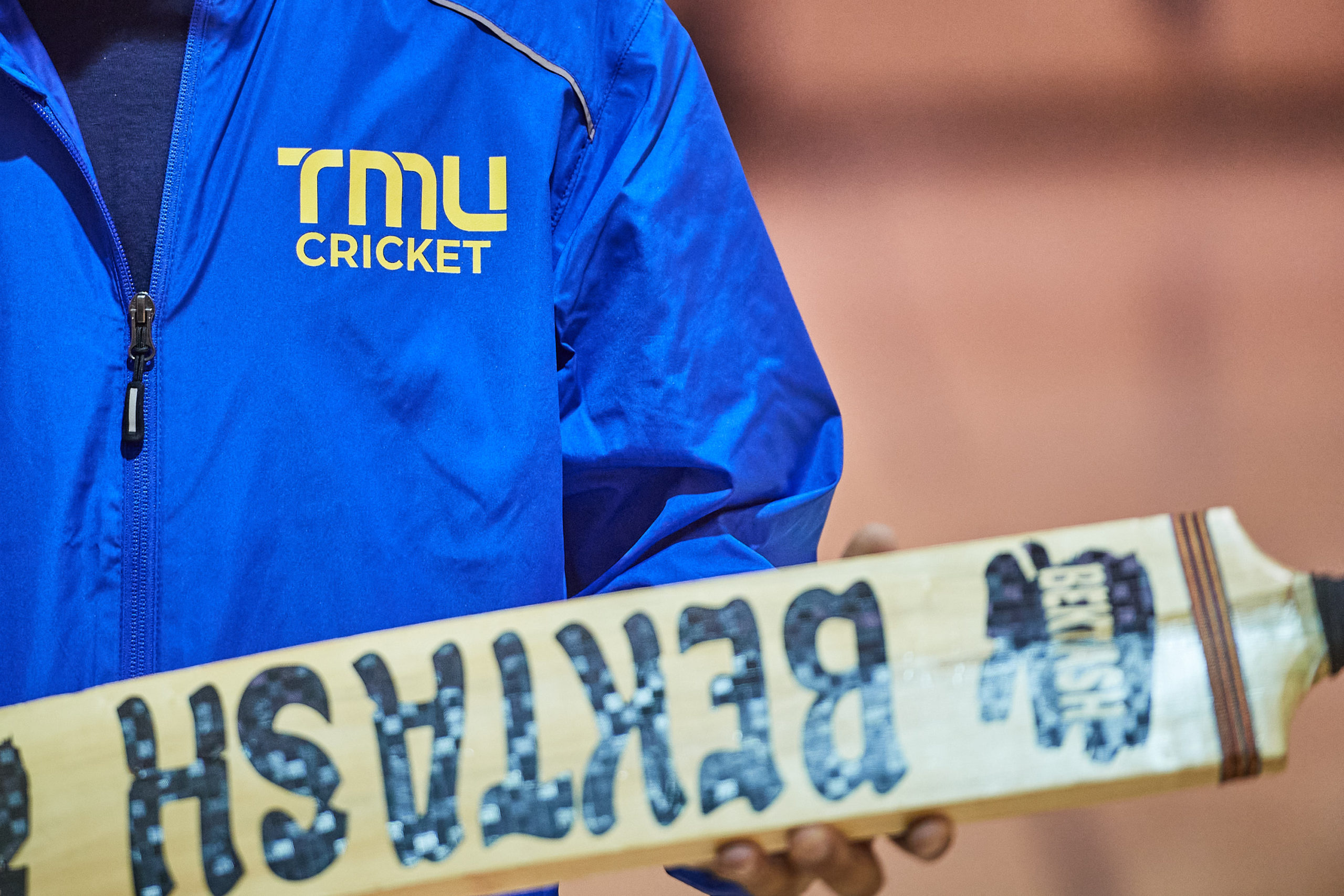 a jacket showing the TMU cricket team logo