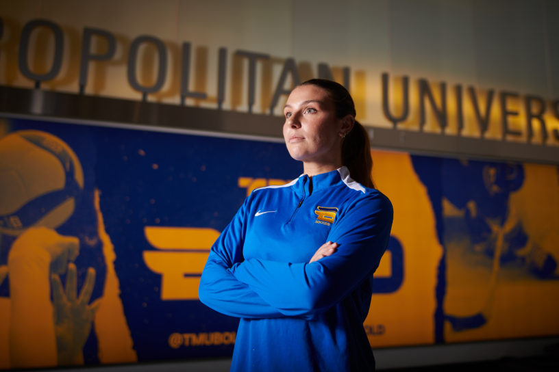 A portrait of Emily Porteous looking up and away from the camera in the hallway at the Mattamy Athletic Centre