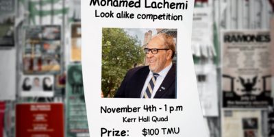 A poster along a blurred out wall, with a photo of Mohamed Lachemi reading "Mohamed Lachemi Look alike competition."