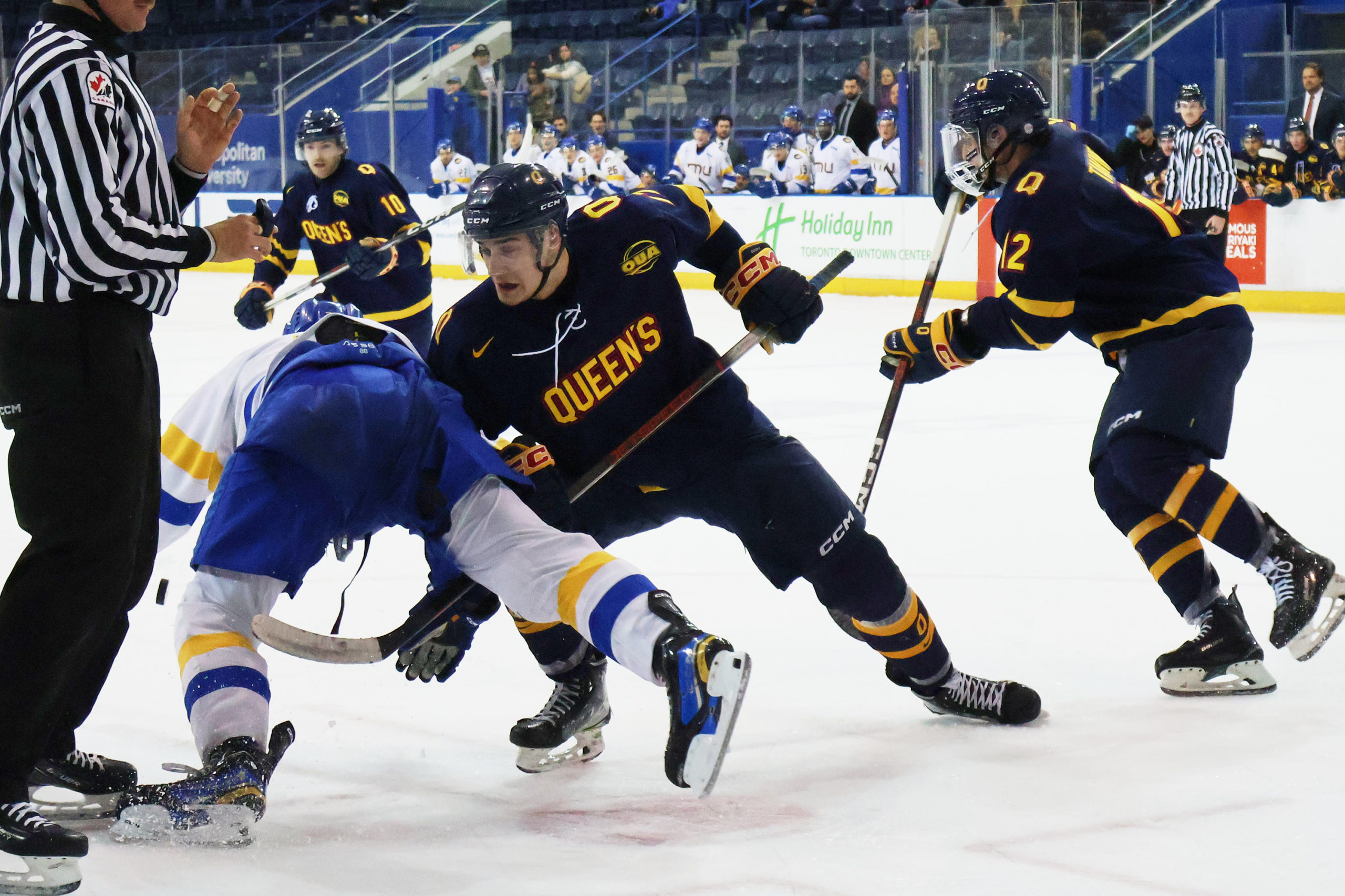 Queen's and Bold players collide near the faceoff dot