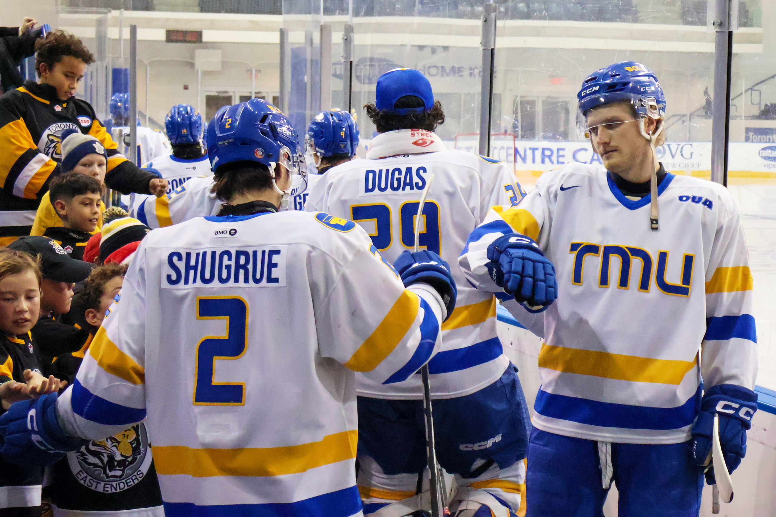 TMU Bold players fist bump on their way to the dressing room