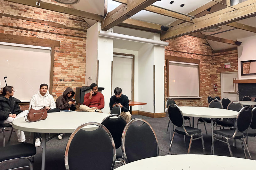 tmsu members sit in corner of empty room with chairs and tables