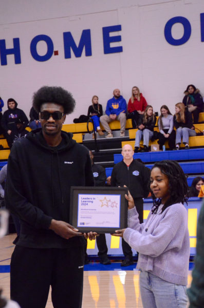 Chris Boucher taking a photo with a scholarship recipient