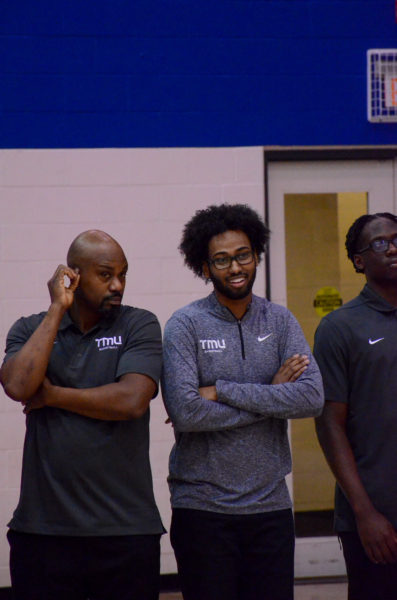 Moustapha Youssuf and TMU Bold staff smile at the sideline