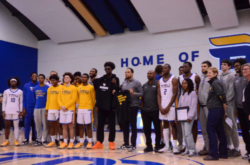 TMU Bold players and staff take a photo with Chris Boucher at centre court