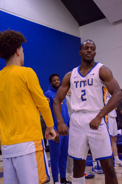 Galand Okeugo flexes his muscles in a pre-game routine with Greg Angelakos