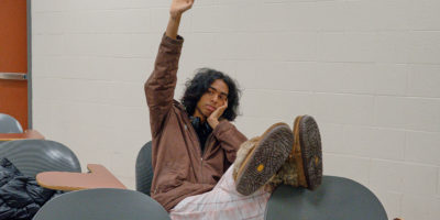 person raising hand bored in classroom