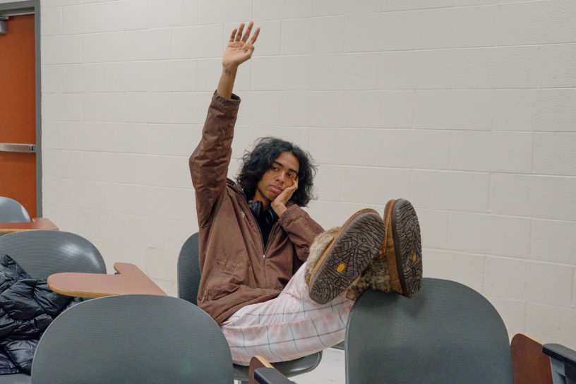 person raising hand bored in classroom